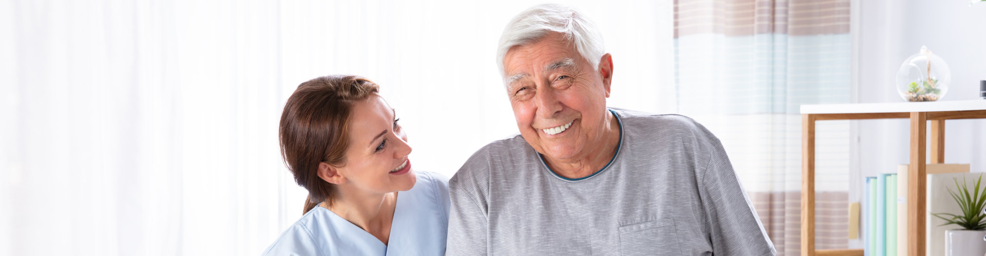 Elderly man and his caregiver smiling